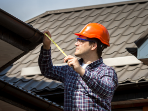 A homeowner documents damage to their roof after a severe storm damaged homes in Castle Rock, Colorado