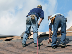 Experienced Castle Rock roofing professionals inspecting and repairing hail damage on a residential roof.